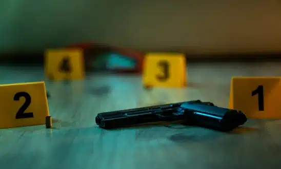 Handgun on a table next to numbered evidence markers