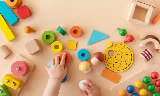 Child's hands reaching for colorful toys and blocks