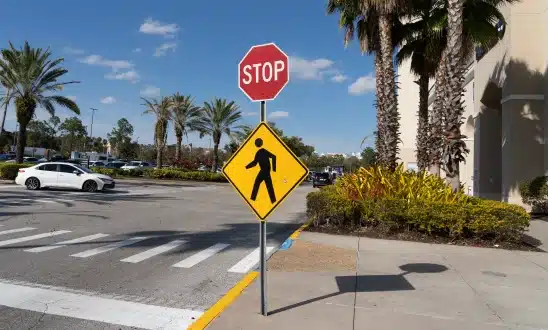 Pedestrian crossing sign and stop sign at a crosswalk